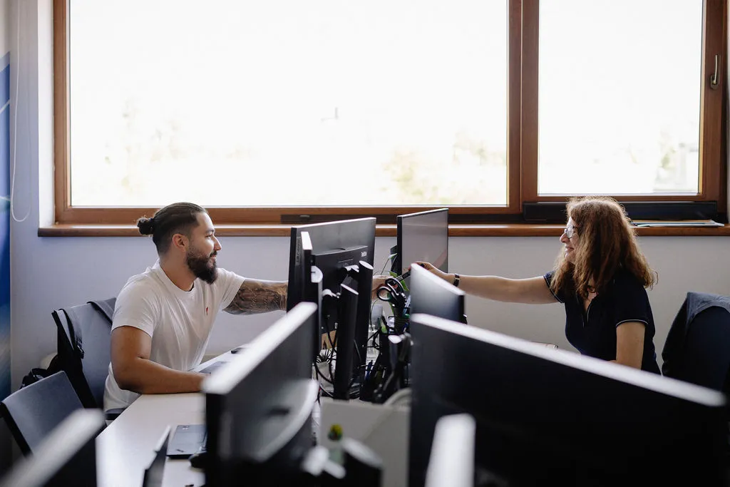 Two phaze01 consultants talking across their desks