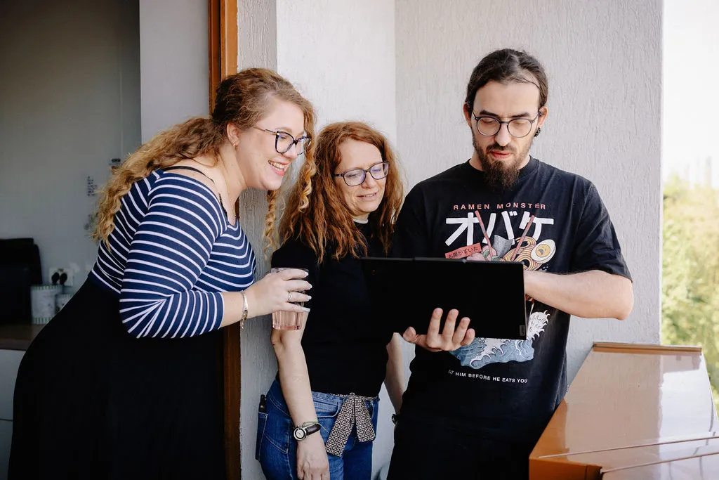Three phaze01 colleagues looking at a laptop together